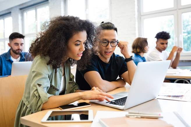 Two people working at a laptop